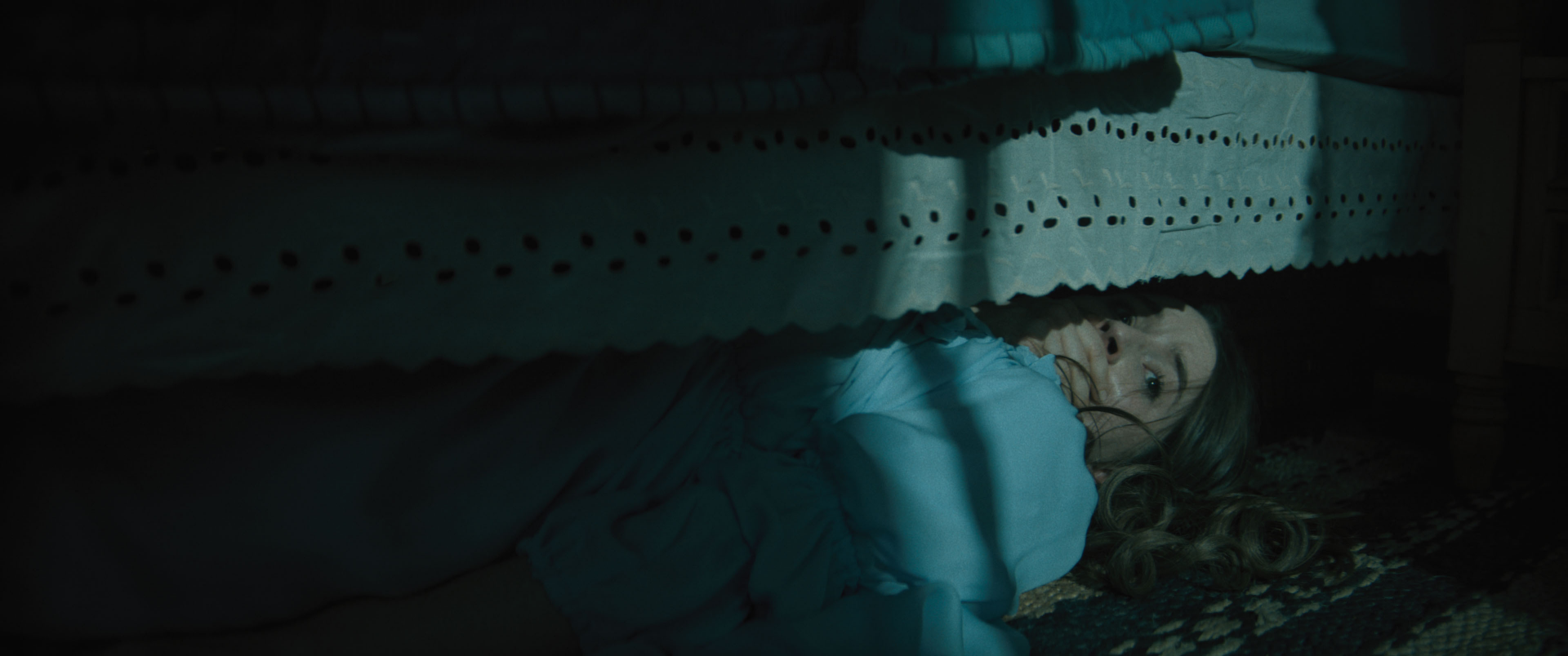 Eerie HD wallpaper featuring a person lying under the bed with a fearful expression, tagged with No One Will Save You, suitable as a suspenseful desktop background.