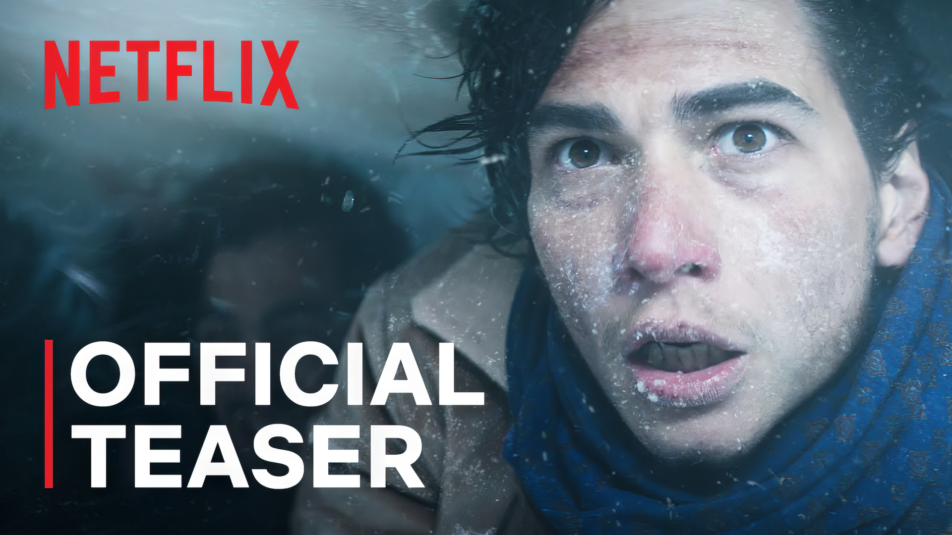 HD wallpaper of Society of the Snow movie with Official Teaser text, featuring a man in snowy conditions, available on Netflix.