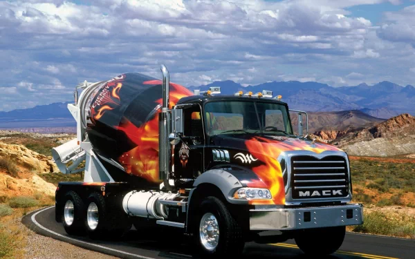 HD desktop wallpaper showcasing a Mack Trucks cement mixer with striking flame graphics, set against a scenic desert landscape under a partly cloudy sky.