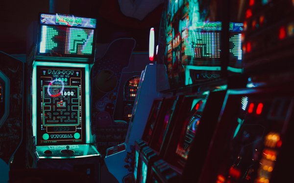 HD wallpaper featuring classic Pac-Man arcade game machine among other retro arcade cabinets, capturing the nostalgic vibe of a vintage arcade room.