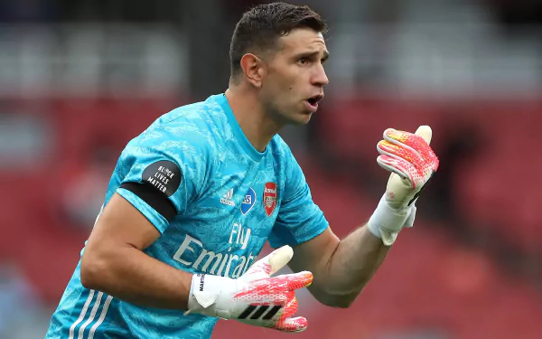 HD desktop wallpaper featuring a focused soccer goalkeeper in action, wearing a teal kit with an Emirates sponsor logo.