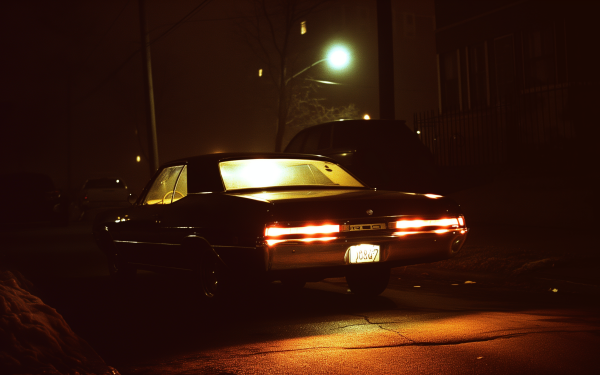 Vintage car with glowing taillights parked at night for a dark aesthetic HD desktop wallpaper and background.