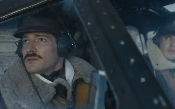 Two actors portraying World War II airmen in the cockpit of a bomber from the TV show Masters of the Air, in a high-definition desktop wallpaper.