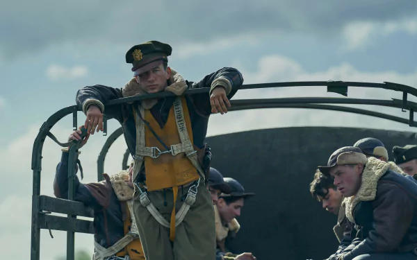HD desktop wallpaper featuring actors dressed as World War II airmen from the TV show Masters of the Air, capturing a somber moment against a cloudy sky backdrop.
