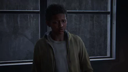 HD PC desktop wallpaper featuring Sam from The Last of Us, shown in a dimly lit room with a somber expression and a window in the background.