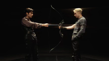 HD desktop wallpaper featuring Stray Kids members Bang Chan and I.N facing each other, with a bow and arrow setup, inspired by the theme of Venom.