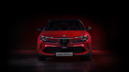 HD wallpaper of a red Alfa Romeo Milano Veloce car against a dark background with subtle lighting.