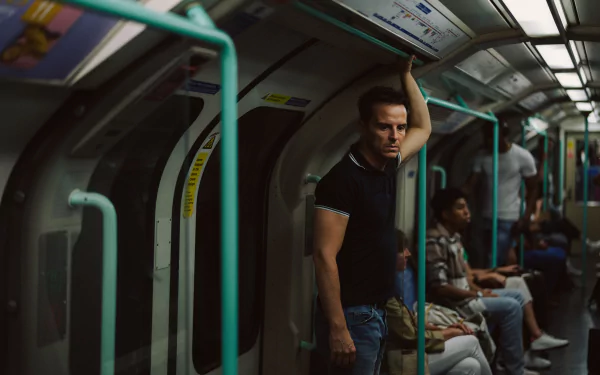 HD desktop wallpaper featuring a moody scene from the movie All of Us Strangers with a contemplative person standing in a subway car.