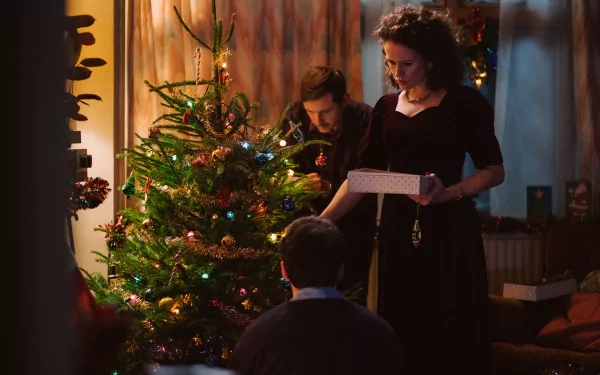 A festive scene from the movie All of Us Strangers, featuring a warm holiday setting with a decorated Christmas tree and characters engaged in joyful celebrations.