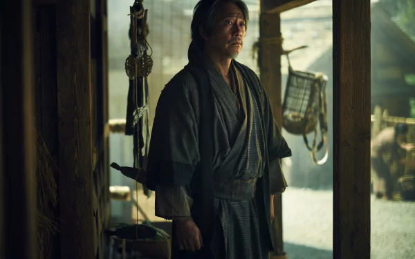 HD wallpaper featuring a scene from the 2024 TV show Shogun with a character dressed in traditional samurai attire standing thoughtfully in a Japanese dwelling.