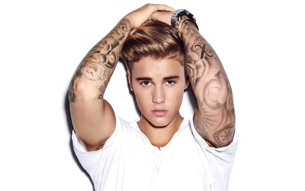 An individual with tattooed arms and a white shirt posing for a HD desktop wallpaper with a music theme.