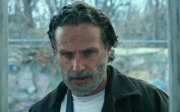 Rick Grimes, portrayed by Andrew Lincoln, is featured in this HD wallpaper from The Walking Dead: The Ones Who Live, capturing his intense expression against a dramatic backdrop.