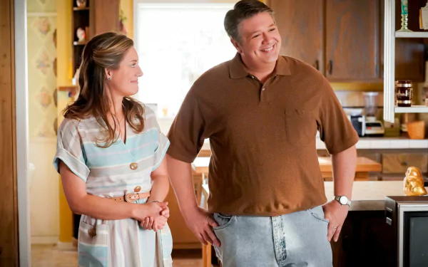 A scene from the TV show Young Sheldon, featuring two characters smiling and interacting in a cozy kitchen setting, showcased as an HD desktop wallpaper and background.