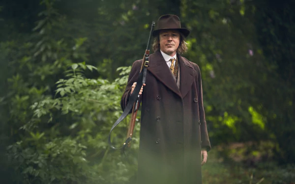 HD wallpaper featuring a character from Peaky Blinders, dressed in a vintage suit and hat, posed in a lush green forest background.