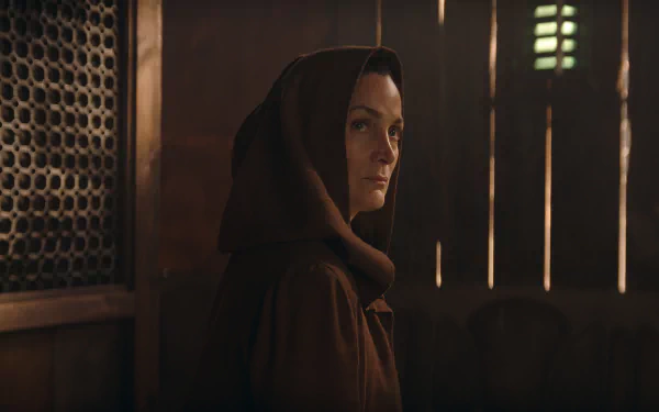 HD desktop wallpaper featuring a mysterious character from The Acolyte TV show, with dimly lit, moody interior setting.