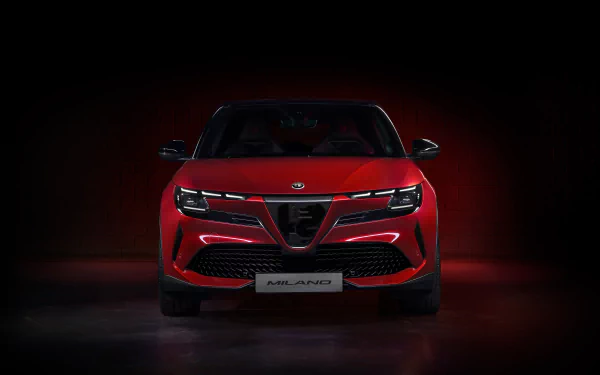 HD wallpaper of a red Alfa Romeo Milano Veloce car against a dark background with subtle lighting.