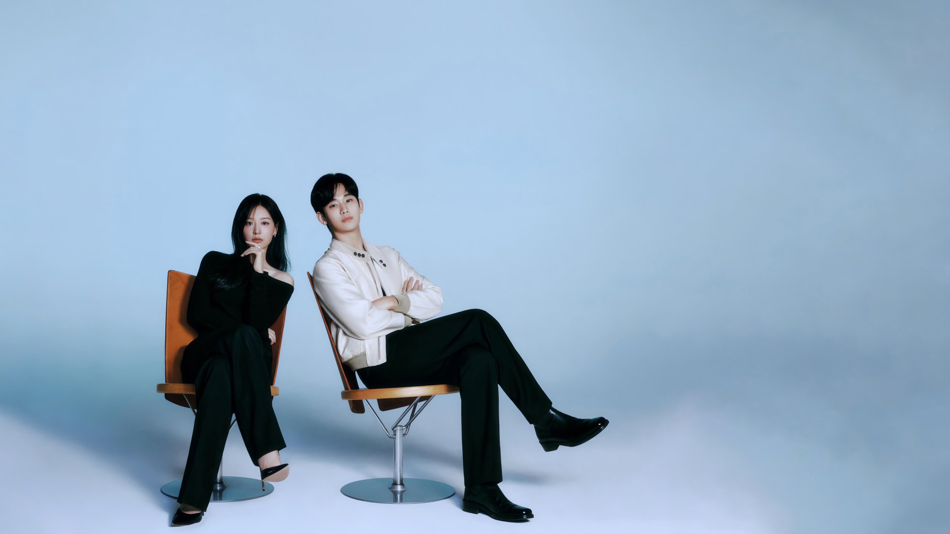 HD wallpaper of two actors from the TV show Queen of Tears, posing confidently on chairs against a blue background.