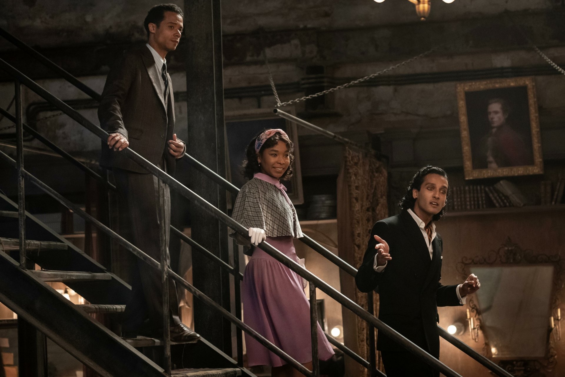 HD desktop wallpaper from Interview with the Vampire TV show featuring three characters descending a staircase in a dimly lit, vintage setting.