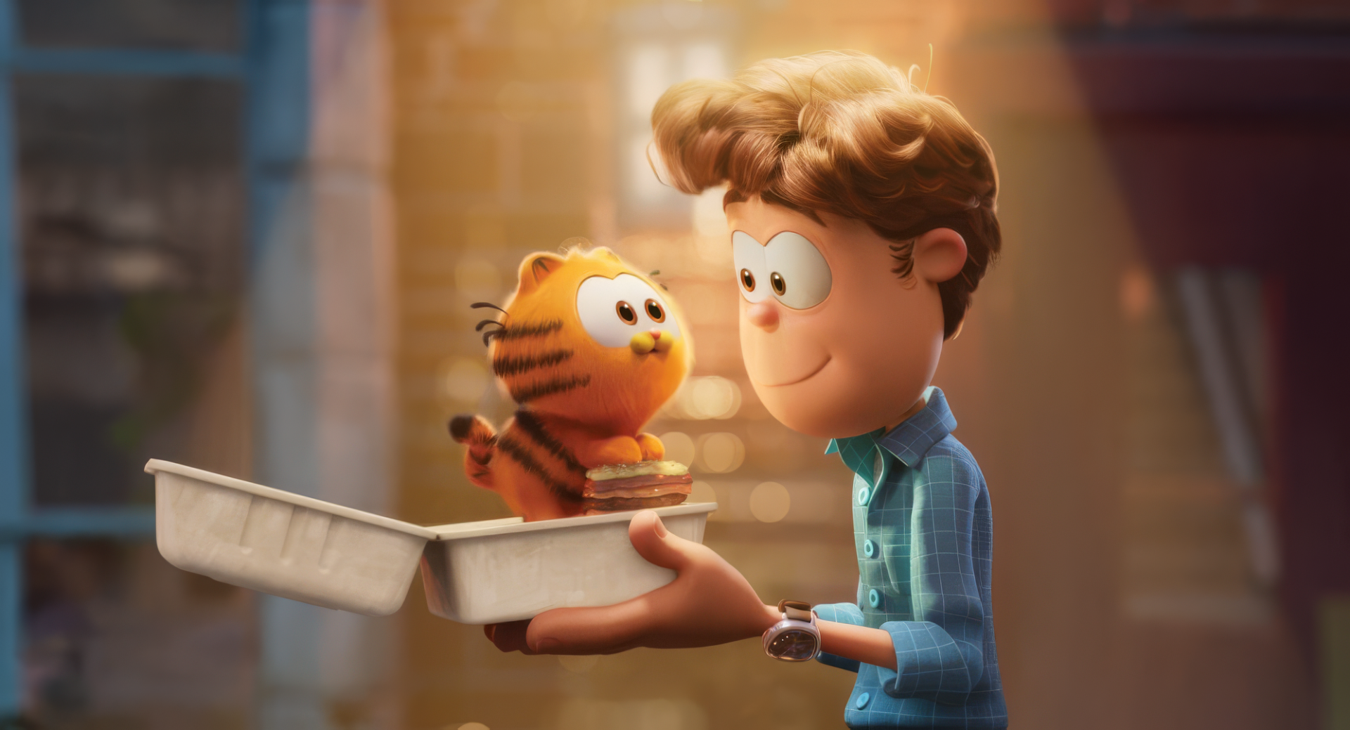 HD desktop wallpaper from The Garfield Movie featuring Garfield and a young boy smiling at each other outdoors.