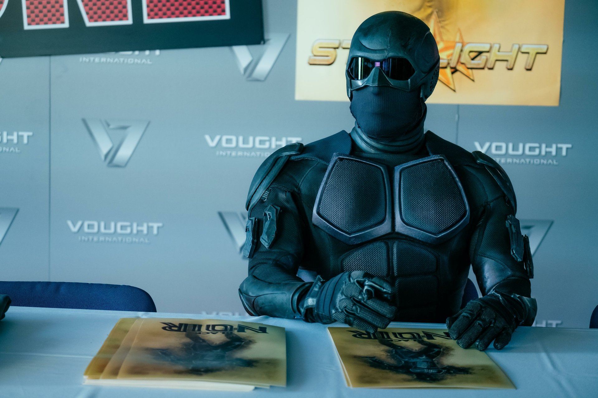 HD desktop wallpaper of Black Noir from the TV show The Boys (2019) signed autographs at a Vought International event.