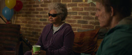 HD desktop wallpaper of a scene from a movie featuring Deadpool and Wolverine, showing two characters sitting and conversing in a brick-walled room.