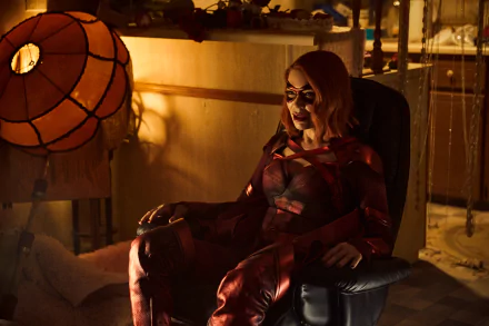 HD desktop wallpaper from The Boys TV show featuring Laurie Holden as Crimson Countess in a dimly lit room, suited up and seated confidently.