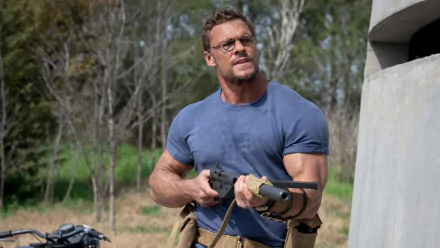 Alan Ritchson in The Ministry of Ungentlemanly Warfare, holding equipment, outdoors, serves as a crisp HD desktop wallpaper.