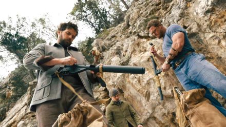 HD desktop wallpaper from the TV show The Ministry of Ungentlemanly Warfare, featuring characters on a rugged terrain with military gear.