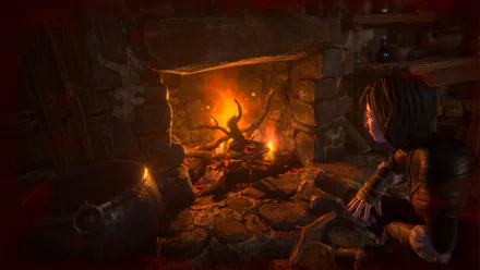 HD desktop wallpaper from the video game Seed of Life, depicting a character warming hands by a cozy fireplace in a rustic stone interior.