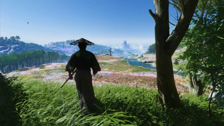 HD desktop wallpaper from the video game Ghost of Tsushima, featuring a samurai overlooking a scenic, flower-filled landscape.