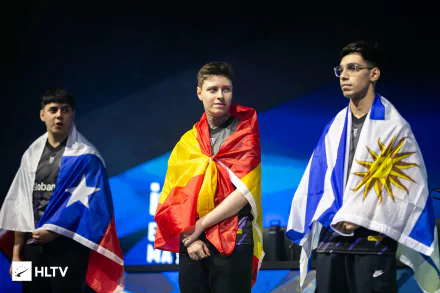 Three esports players from 9z Globant, draped in their national flags, stand on stage at a video game tournament. HD desktop wallpaper.