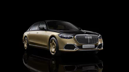 HD wallpaper of a black and gold Mercedes-Maybach S 680 luxury car with a sleek, reflective background.