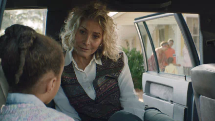 A scene from the movie Sound of Hope: The Story of Possum Trot showing two people having a conversation inside a car, with others in the background near a house. HD desktop wallpaper and background.