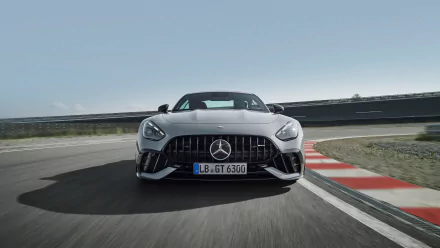 Front view of a Mercedes-AMG GT63 PRO speeding on a racetrack, captured in an HD desktop wallpaper and background.