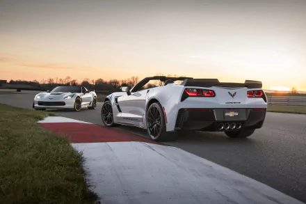 HD image of two Chevrolet Corvette Carbon 65 Edition cars on a racetrack at sunset, set as a desktop wallpaper and background.