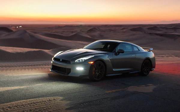A Nissan GT-R car sits against a desert backdrop at sunset, serving as a stunning HD desktop wallpaper.
