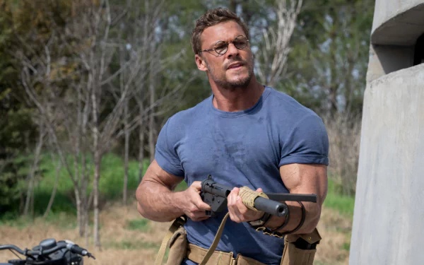 Alan Ritchson in The Ministry of Ungentlemanly Warfare, holding equipment, outdoors, serves as a crisp HD desktop wallpaper.