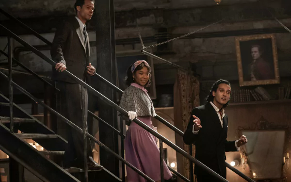 HD desktop wallpaper from Interview with the Vampire TV show featuring three characters descending a staircase in a dimly lit, vintage setting.