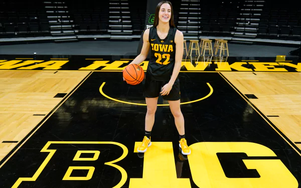 HD desktop wallpaper of basketball player Caitlin Clark on a Big Ten court, ready to play in her Iowa Hawkeyes uniform (#22).