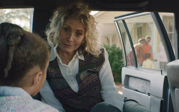 A scene from the movie Sound of Hope: The Story of Possum Trot showing two people having a conversation inside a car, with others in the background near a house. HD desktop wallpaper and background.