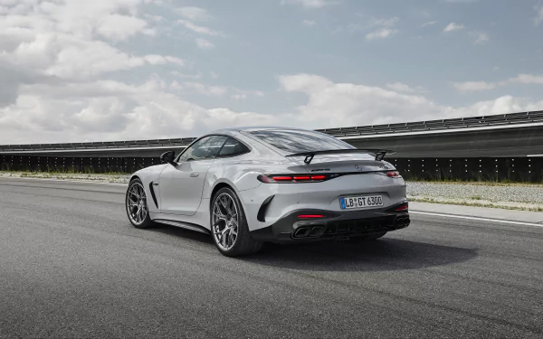 HD desktop wallpaper featuring a sleek Mercedes-AMG GT63 PRO on an open road under a partly cloudy sky.