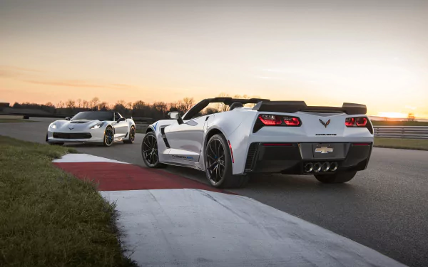 HD image of two Chevrolet Corvette Carbon 65 Edition cars on a racetrack at sunset, set as a desktop wallpaper and background.