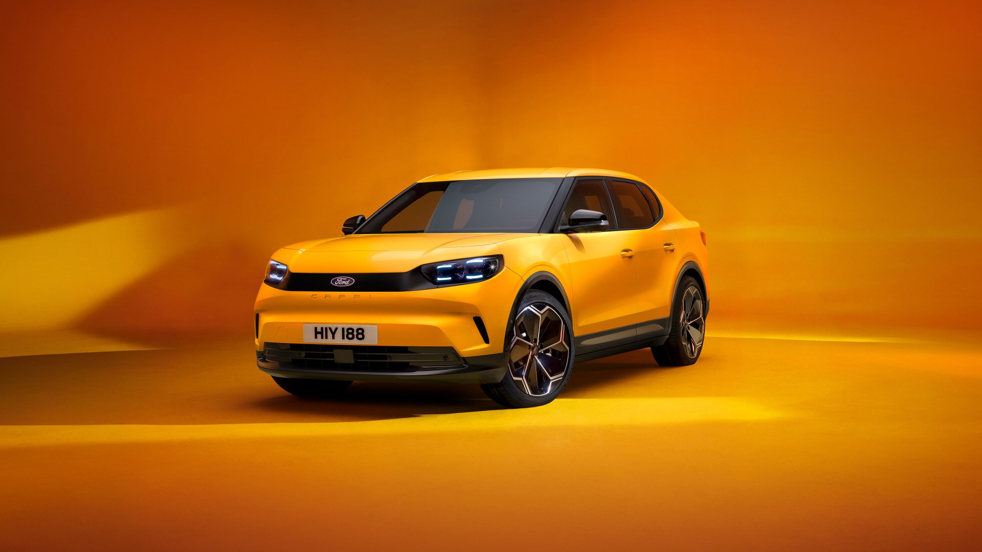 A vibrant yellow Ford Capri showcased against a warm orange background, designed as an HD desktop wallpaper and background for car enthusiasts.