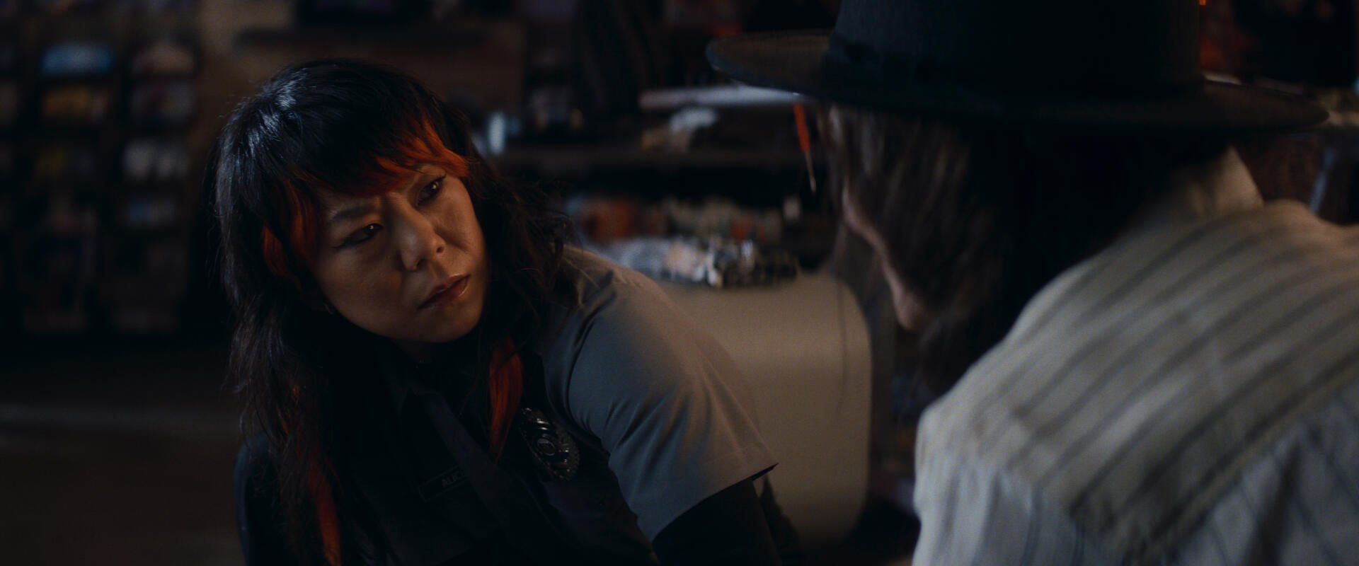 A tense moment from a TV show, featuring two characters engaged in a serious conversation, captures the intrigue of Agatha All Along. This HD image serves as a striking desktop wallpaper.