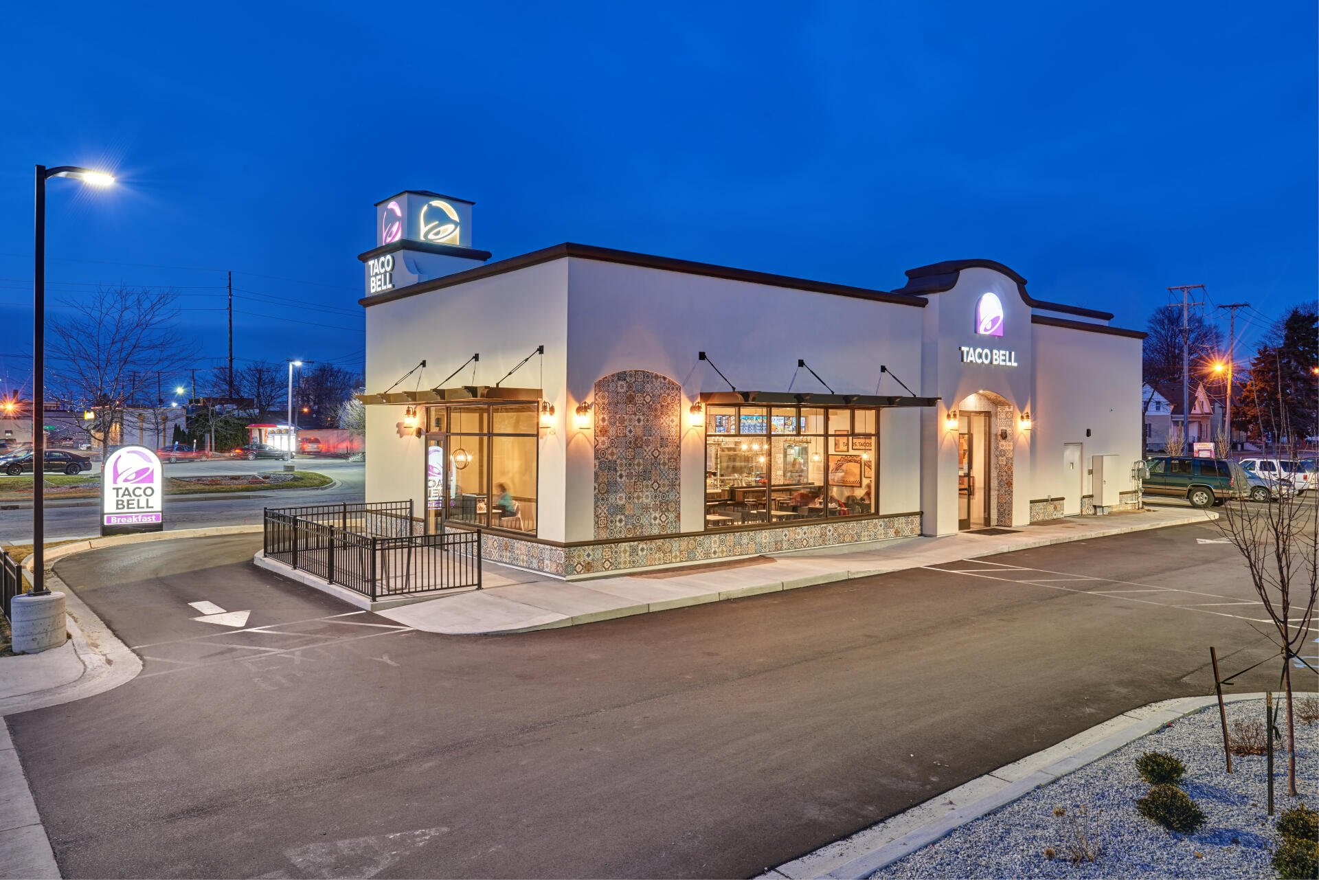 4K Ultra HD image of a man-made Taco Bell fast food restaurant at dusk, featuring illuminated signage and a quiet parking area.