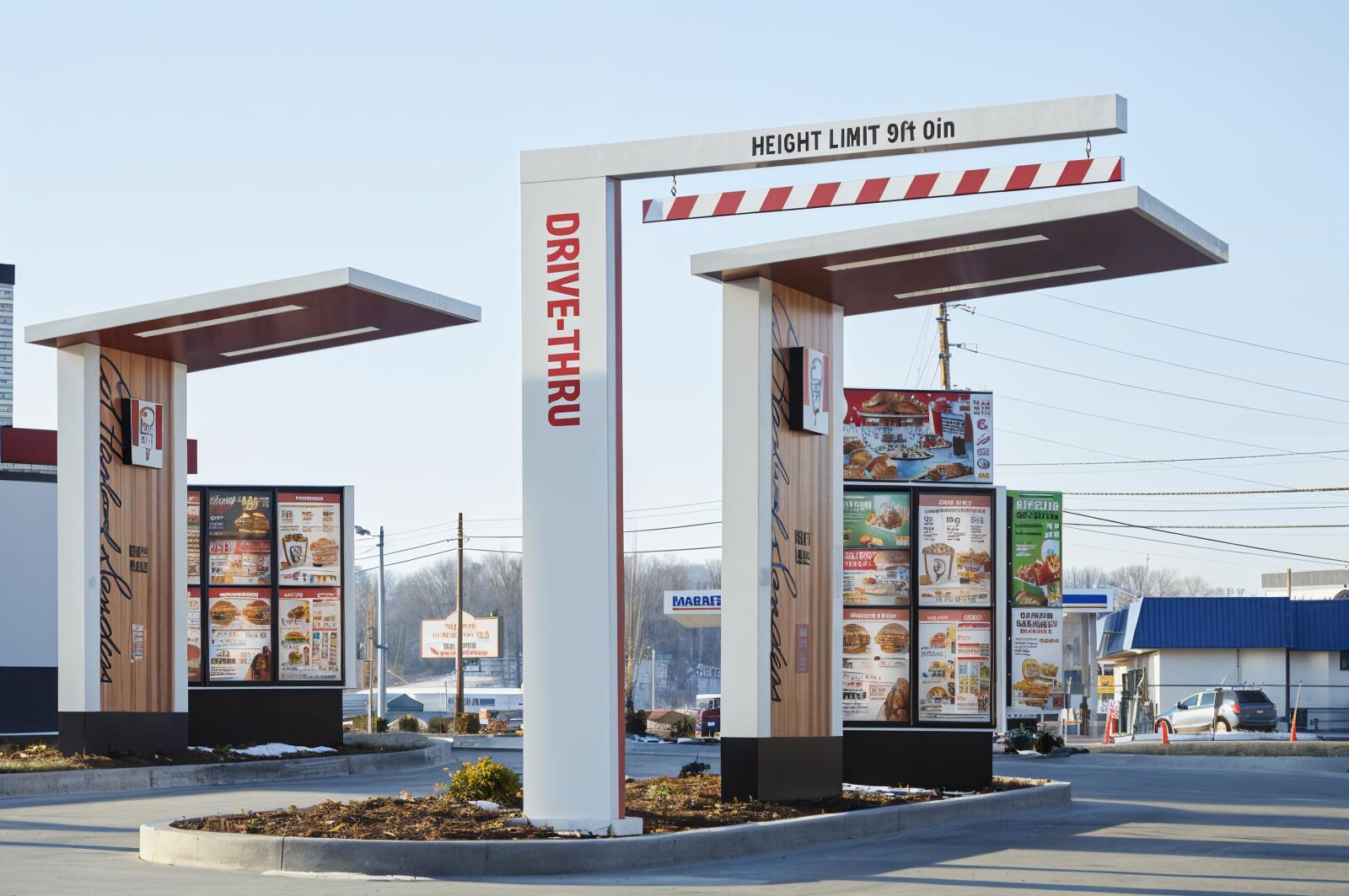 A vibrant HD desktop wallpaper featuring a KFC drive-thru, showcasing the menu boards and a height limit sign in a bright, clear setting.
