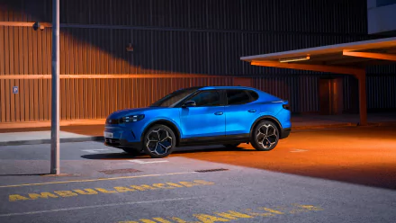 A vibrant blue Ford Capri parked in an urban setting, illuminated by warm lighting. This HD wallpaper captures the sleek design and modern appeal of the iconic car.