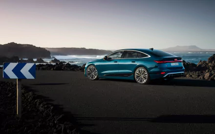 A stunning Audi S6 E-Tron parked on a coastal road with a clear view of the ocean, showcasing its sleek design against a picturesque backdrop. HD desktop wallpaper.