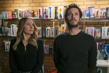 Kristen Bell and Adam Brody stand in a shop filled with colorful products in a scene from the TV show Nobody Wants This. The image serves as a vibrant HD desktop wallpaper.