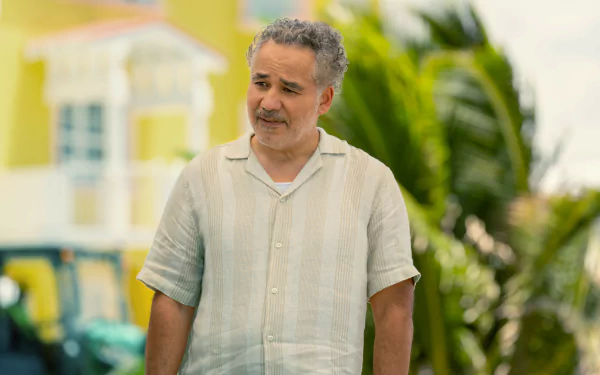 A scene from the TV show Bad Monkey featuring John Ortiz outdoors, surrounded by lush greenery, creating a vibrant HD desktop wallpaper and background.